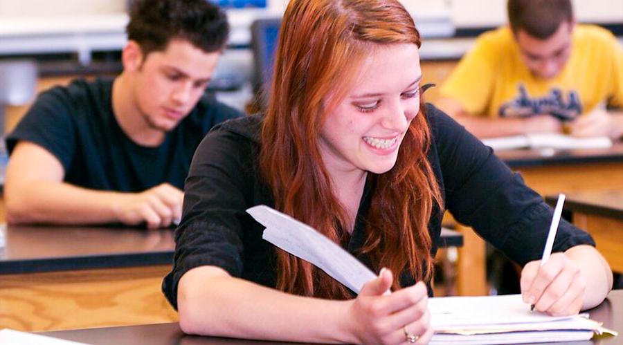 young woman with red hair sitting in class